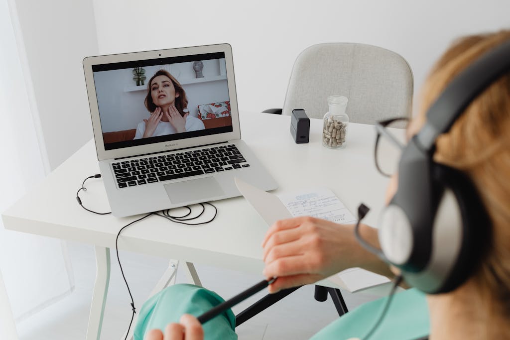 A healthcare professional video conferencing with a patient for an online consultation.